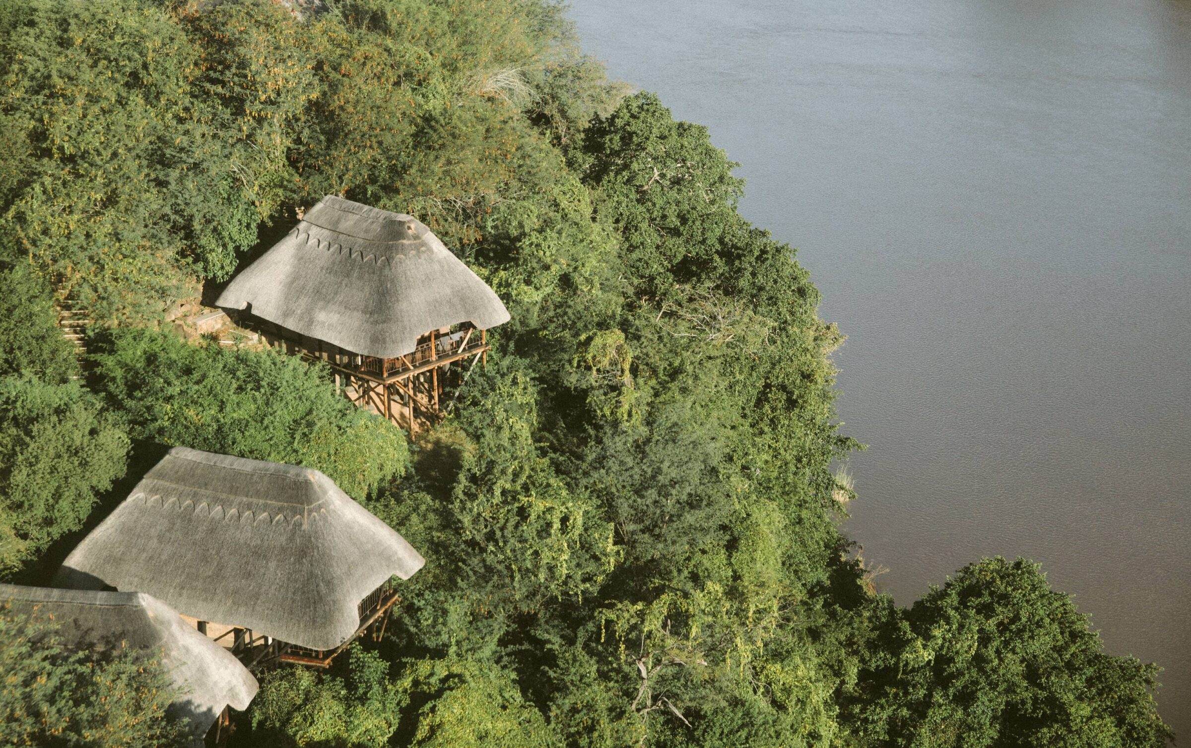 Thatched cliff-edge chalets of Chilo Gorge Safari Lodge above the Save River, Gonarezhou, Zimbabwe