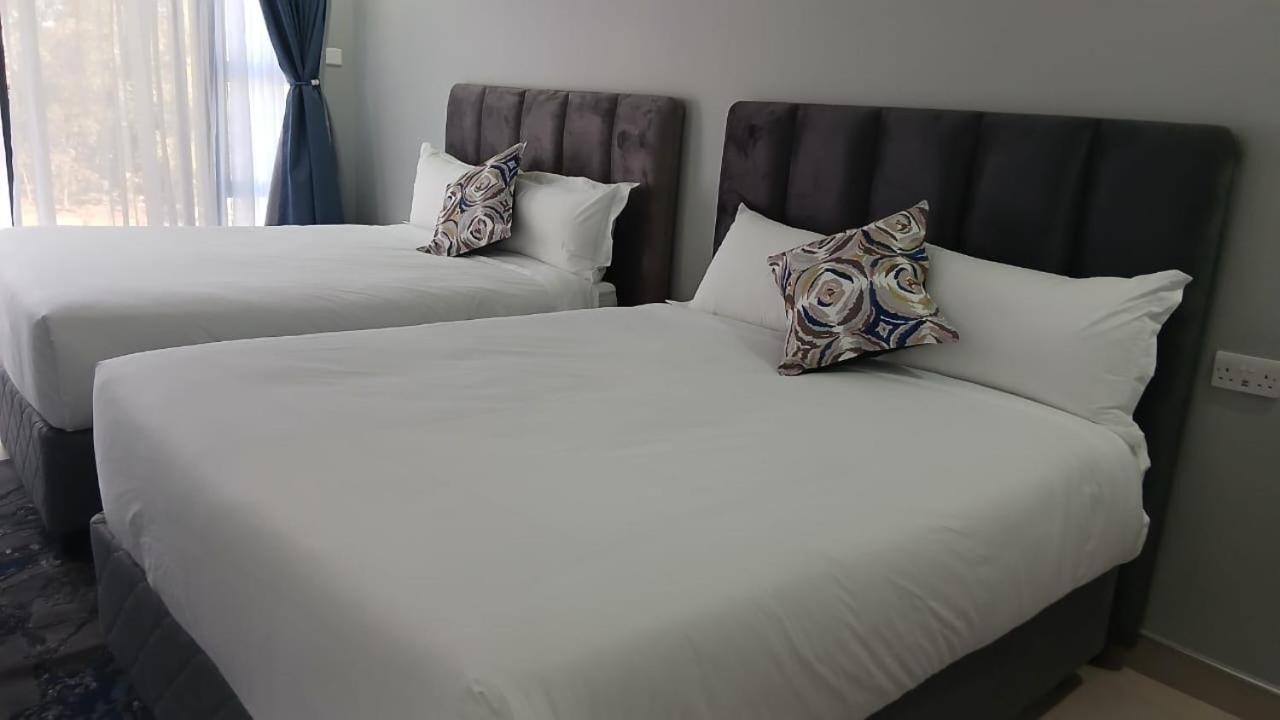 A room with two double beds at Gohori Resort, Mutoko