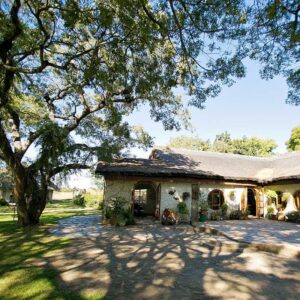 Imire Lodge thatched main building and lawn, Hwedza, Zimbabwe